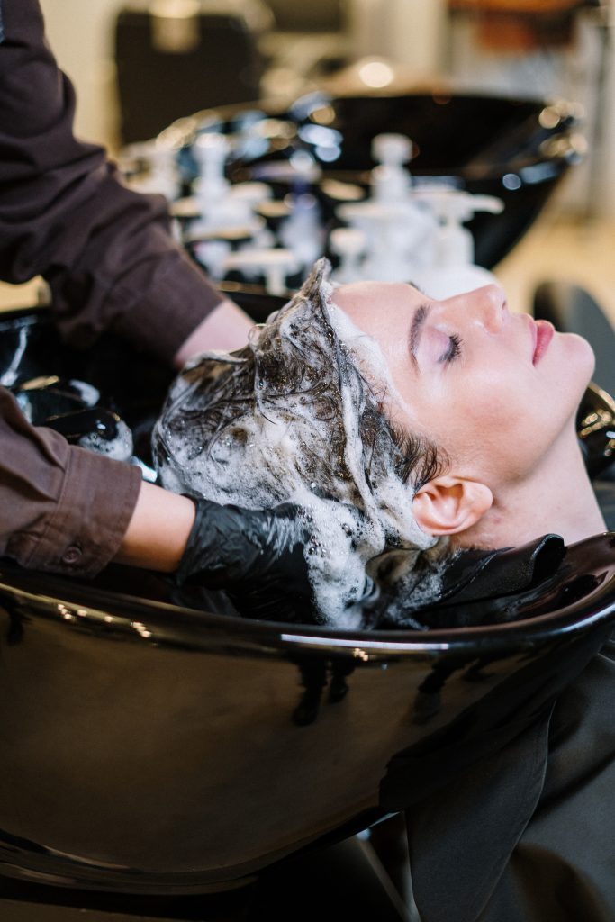 Hairdresser washing customer's hair
